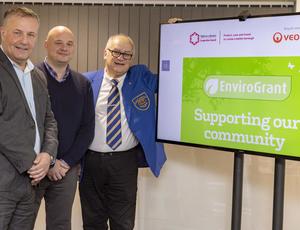 Photo of a grant recipient with representatives from Veolia and Telford & Wrekin Council next to a green EnviroGrant logo
