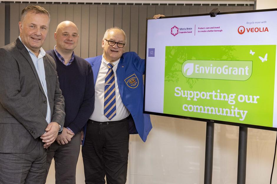 Photo of a grant recipient with representatives from Veolia and Telford & Wrekin Council next to a green EnviroGrant logo